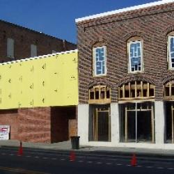Windows installed in second floor and boards put up on one story level in preparation for stucco work. 