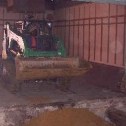 A construction worker hauling in dirt to level the floor in the oldest half of the building.