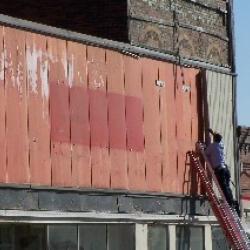 The old vinyl siding is removed from the front of the building.