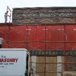 Employees from Harvey Dial Masonry set up scaffolding in order to do some brick repair work.